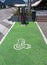 Electric Vehicle EV Charging Station parking spot with icon  text on aging green painted pavement