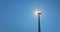 Electric Windmill against blue sky and sun. Wind Power Turbine, Renewable Energy.