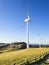 Electric windmills on a grass hill