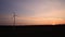 Electric windmills power generator silhouette at sunset