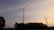 Electric windmills power generator silhouette at sunset