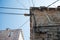 Electric wires attached on an old stone house. Old architecture. Electricity transmission. Light bulb on the building. Street ligh