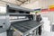 Electrical engineer operator repairs large industrial printer and plotter machine