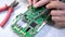 Electrical engineer soldering on printed circuit board