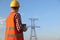 Electrical engineer with walkie talkie near high voltage tower