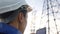 Electrical engineer worker in helmet silhouette working at sunset near tower with electricity. Business energy