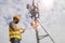 Electrical engineers work on telecommunication. tower.lj.Helmets and safety equipment use smartphones near the signal towers tall