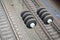 Electrical insulators on the contact wires on the background of a blurred railway track. Macro photo with selective focu