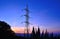 Electrical pylon among bushes backlit before sunrise