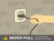 Electrical safety rules and tips. Never pull a plug from an outlet by its cord. Close-up view of socket.