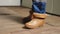 Electrical technician is putting on special protective shoes in power station. Electrician wears rubber boots for safety