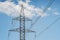 Electrical tower pylon and wires on a blue sky with clouds.