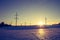 Electrical tower on a snowy field. Sun goes down, orange colors, evening scenery