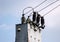 electrical wires extending from the transformer station near the railway on a background of blue sky.