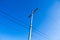 Electrical wires on a pole on blue sky background.