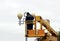 Electrical worker repairing the wires on the pole with the help of the lift car.