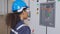 Electrical young asian woman engineer examining maintenance cabinet system electric and using tablet in control room