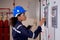 Electrical young asian woman engineer examining maintenance cabinet system electric and using tablet in control room.