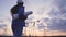 An electrician against the background of power plants at sunset, working on a project for supplying voltage, a young