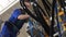 Electrician checks cables at switchboard in workshop