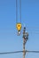 Electrician climbing work in the height on concrete electric power pole with yellow big crane