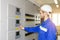 Electrician Engineer on control board. Worker controls industrial processes.