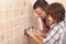 Electrician father teaching son how to install electrical socket