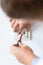 Electrician hands tighten bolts in wall fixture or socket using screwdriver.