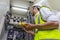 Electrician installing electric cable wires and fuse switch box. Multimeter in hands of electricians detail.Electrician repairing