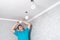 electrician installing modern LED ceiling spotlights.