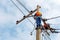 Electrician lineman repairman worker at climbing work on electric post power pole