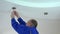 Electrician man install or replace halogen light lamp into ceiling