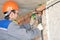 Electrician man worker installing electrical cable at house wall