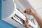 Electrician repairing air conditioner indoors, closeup