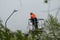 An electrician in special clothing and a helmet repairs a street lamp and screws a street light bulb on a special lifting platform