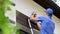 Electrician standing on ladder and change the light bulb