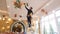 electrician standing on ladder and in gloves wipes dust cleaning lamp on ceiling