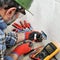 Electrician technician working safely on a residential electrical system.