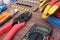 Electrician tools with red and blue wire laid out on a wooden surface of dark color