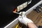 An electrician in white gloves is installing a TV socket and satellite connector in the black wall of the room.