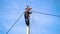 An electrician working at a newly installed utility pole - connects a new power line.