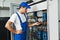 Electrician works with electric meter tester in fuse box