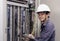 Electricians smiling, inspecting electrical boxes in the industrial factory