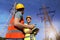 Electricians in uniforms near high voltage towers