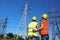 Electricians in uniforms near high voltage towers