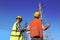 Electricians in uniforms near high voltage towers