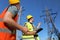 Electricians in uniforms near high voltage towers