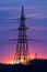 Electricity poles at sunset. High voltage grid towers with wire cable at distribution station