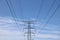 Electricity pylon against blue wispy cloudy sky with space for copy