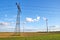 Electricity pylon with overhead lines and wind turbines